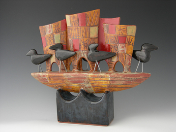 mlschumacher clay sculpture featuring 5 ravens on multi sail boat glazed with red, amber, and green pattern.