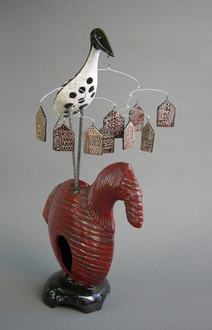 mlschumacher clay sculpture of black and white crane on red horse with mobile of black and white houses with sgrafitto drawings of pictograms and pseudowriting.              Picture